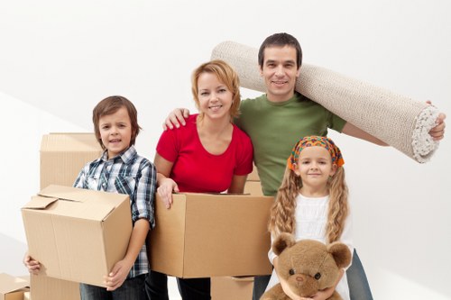 Professional movers handling boxes and household items in a Teddington property