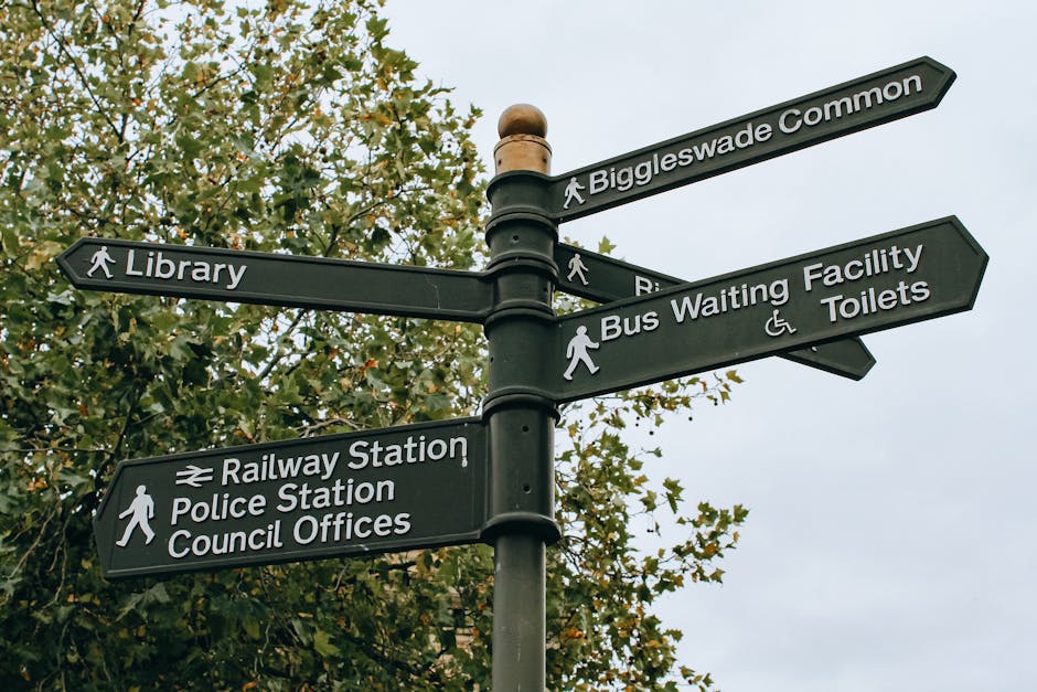 Close-up image of a rectangular white parking sign mounted on a wooden post with four screws, situated in front of a red brick wall. The sign features two sections: the top section displays a blue background with a white wheelchair symbol, indicating accessible parking, and the bottom section has a large white letter 'P' on a blue background, signifying parking area. To the right of the wheelchair symbol, the text reads 'Blue badge holders only,' indicating that parking is restricted for authorized permit holders. The sign is outdoors, and sunlight casts shadows on the brick wall background. This parking sign pertains to regulations related to house removals and the transportation of furniture, supporting moving logistics and home relocation services provided by companies like Man With a Van Teddington, especially in contexts where parking permits or restricted access areas are relevant for effective house removals.